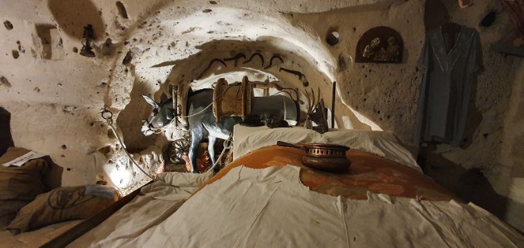 A bed in a cave with a pot on top of it.