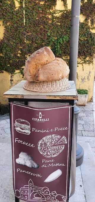 A large loaf of bread is sitting on top of a wooden table.