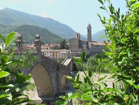 A bridge over a river with a city in the background
