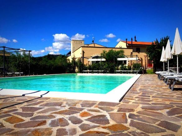 A large swimming pool surrounded by chairs and umbrellas