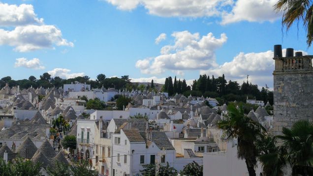 A city with a lot of white buildings and palm trees
