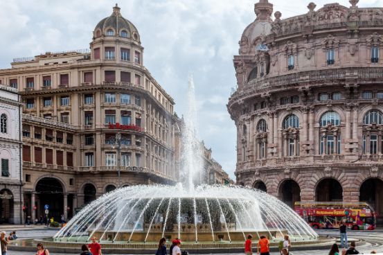 A fountain in the middle of a city in front of a building.