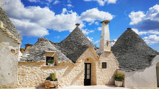 A house with a chimney on the roof is surrounded by other houses.