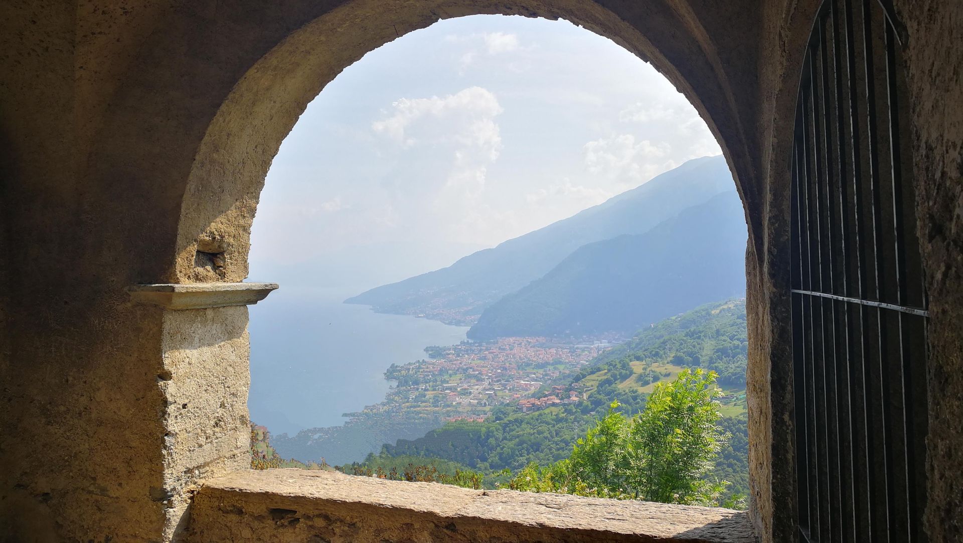 Scenic lake and mountain view framed by an ancient stone archway.