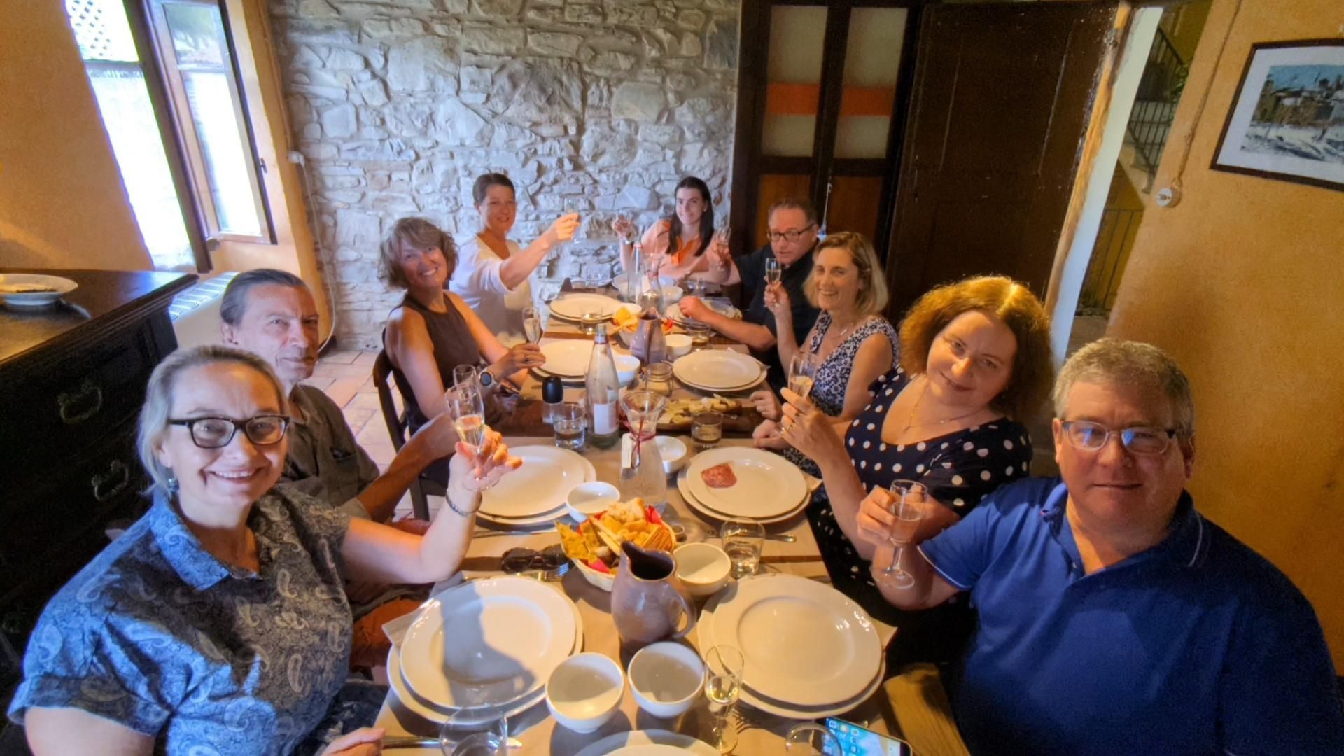 A group of people are sitting at a table with plates and glasses.