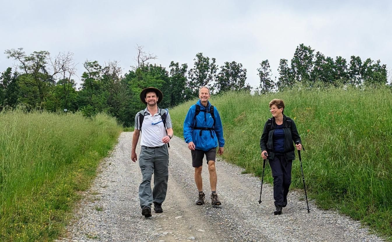 A group of people are walking down a dirt road.