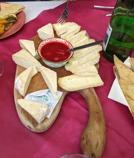 A wooden cutting board with cheese and sauce on it