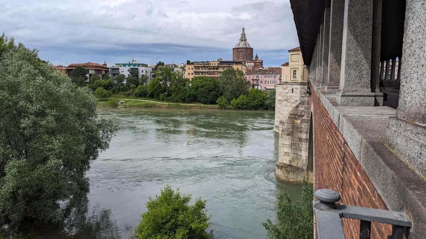 A bridge over a river with a city in the background.