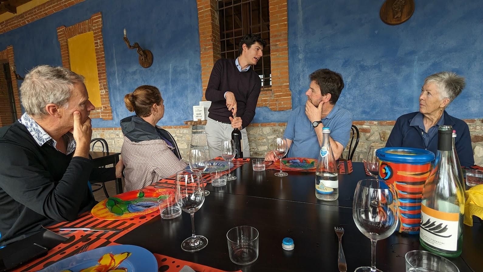 A group of people are sitting around a table with wine glasses.