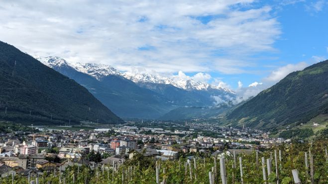 A city in the middle of a valley with mountains in the background.