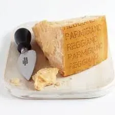A wedge of Parmigiano-Reggiano cheese with a textured rind, cheese knife, and crumbled pieces on a white plate.