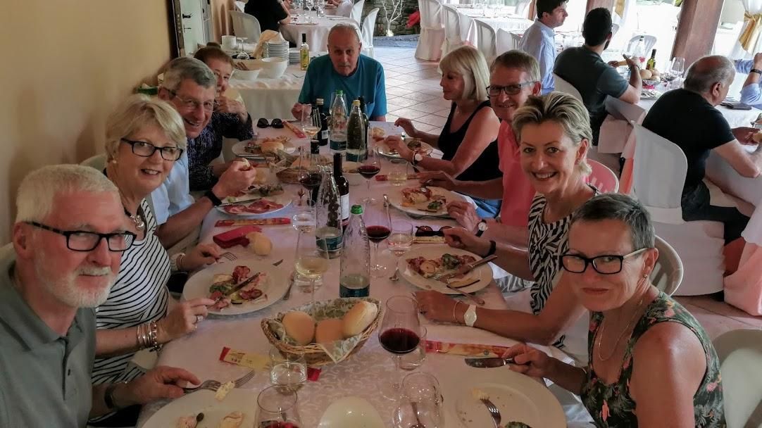 A group of people are sitting at a long table eating food.