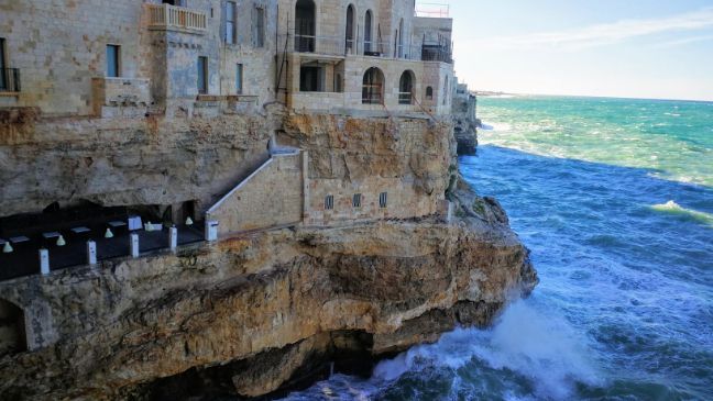 A building on a cliff overlooking the ocean.