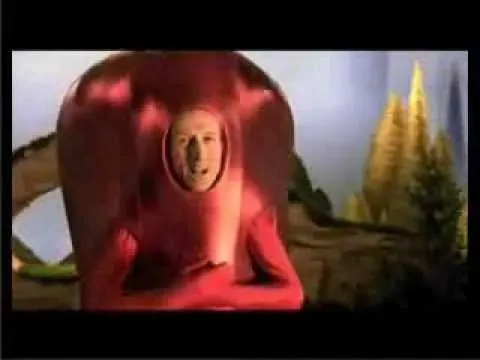 A person in a surreal red costume with their face exposed, set against a fantasy-like background.