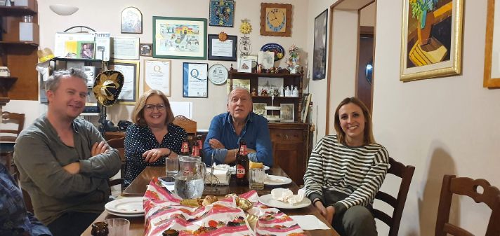 A group of people are sitting around a table in a living room.