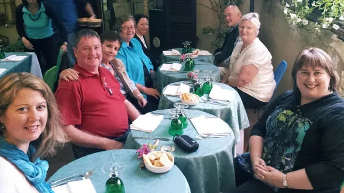 Casual outdoor dining—friendly group, cozy setting, Italian trattoria style.