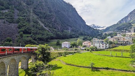 A train is going over a bridge in the mountains.