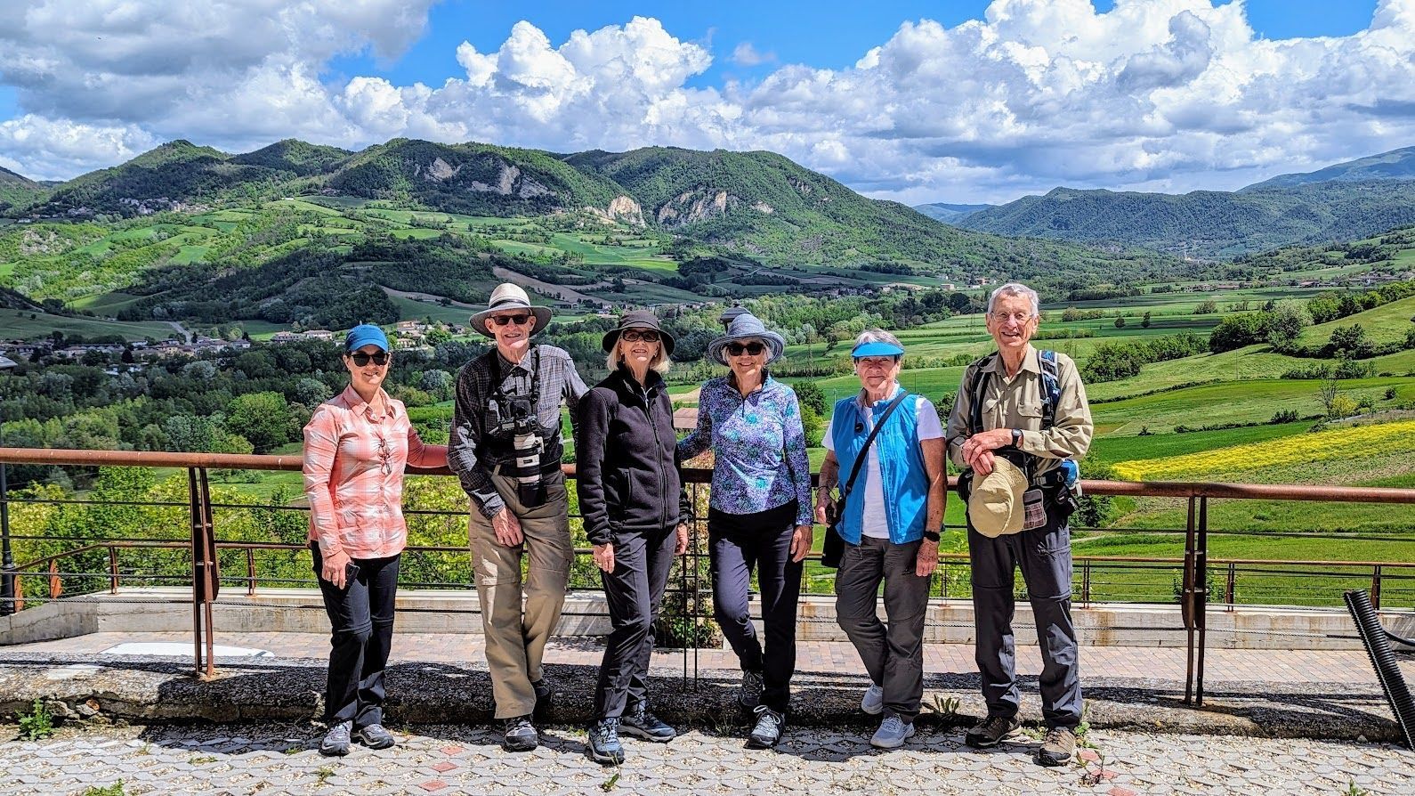 A group of people are posing for a picture in front of a mountain range.