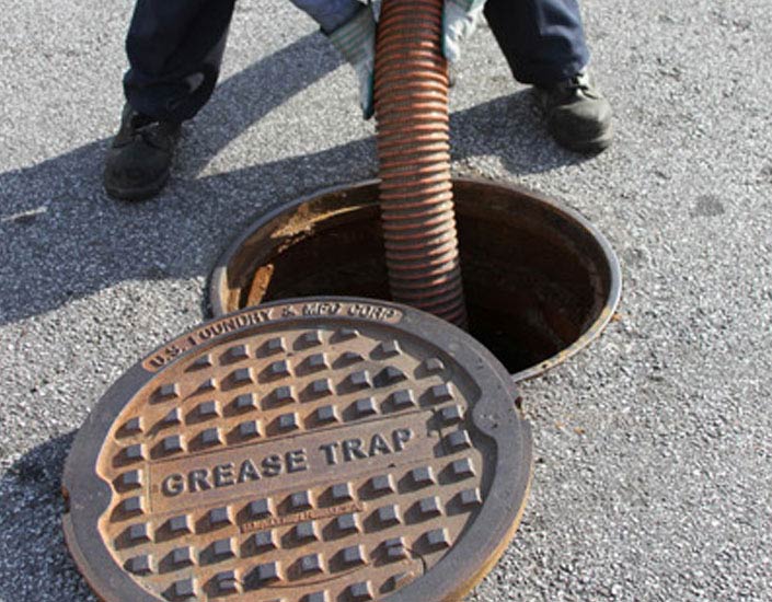 A manhole cover that says grease trap on it