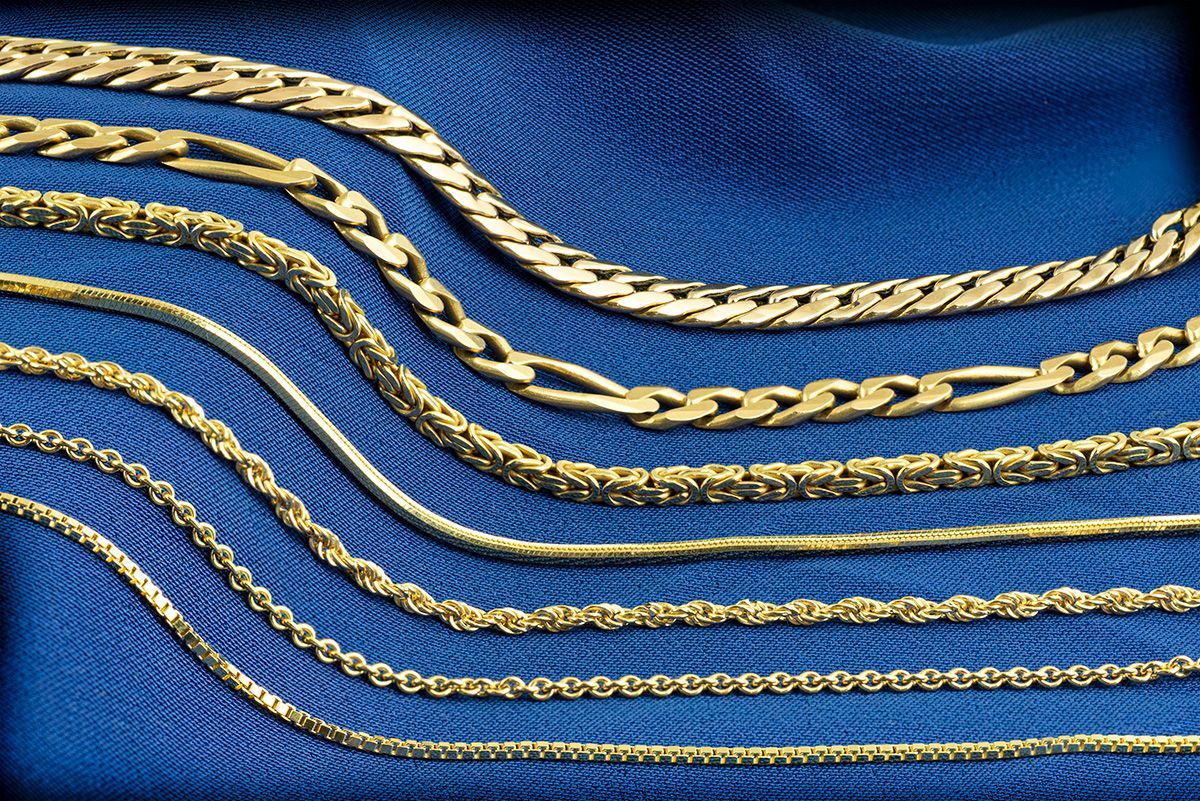 Gold necklaces on a blue background, various chain styles displayed.
