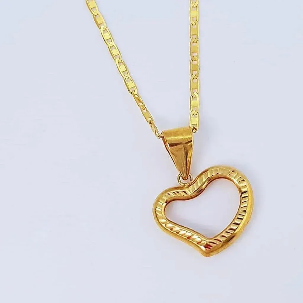 Gold heart pendant necklace on a white surface.
