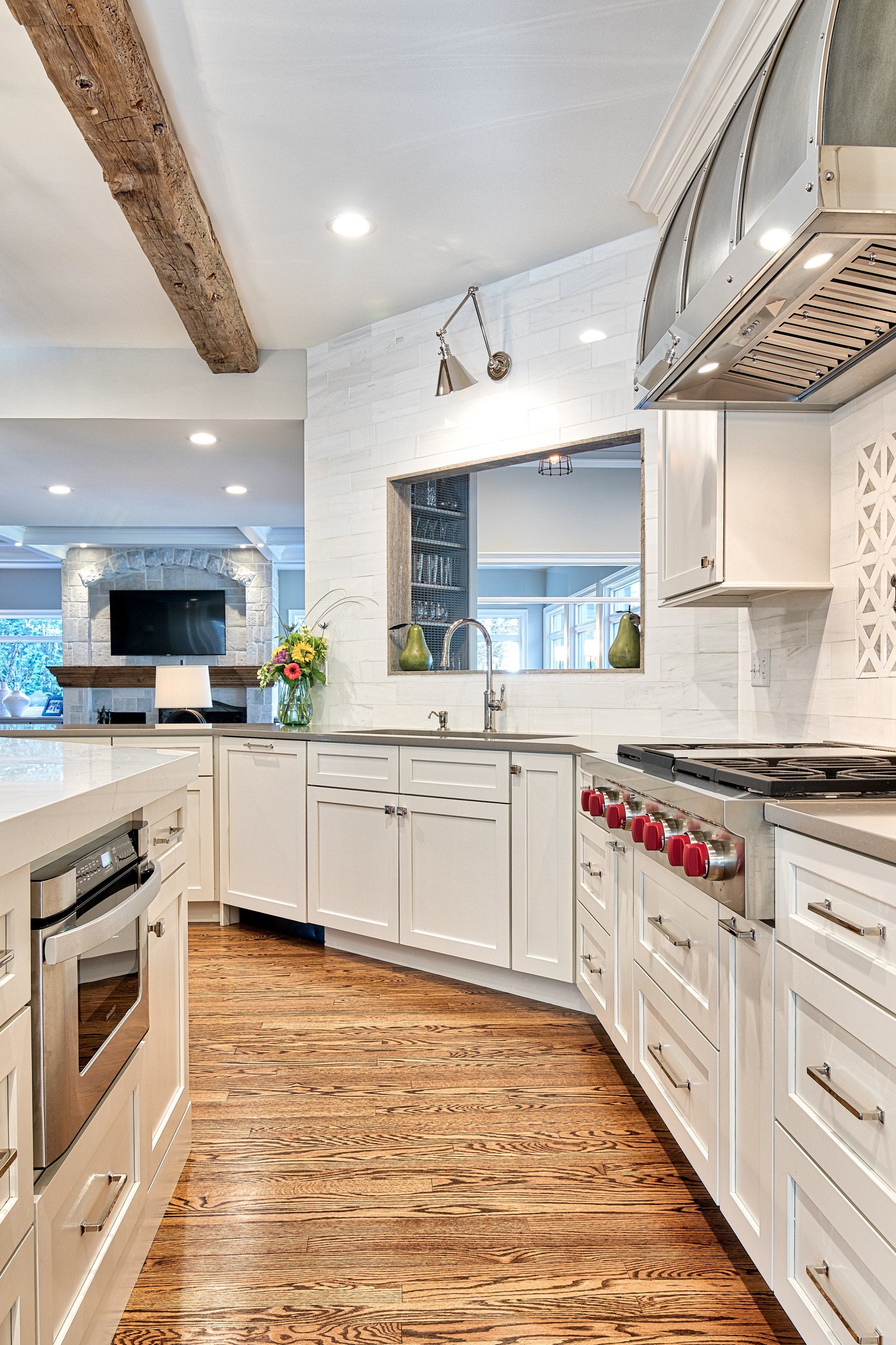 A kitchen with white cabinets , stainless steel appliances , and wooden floors.