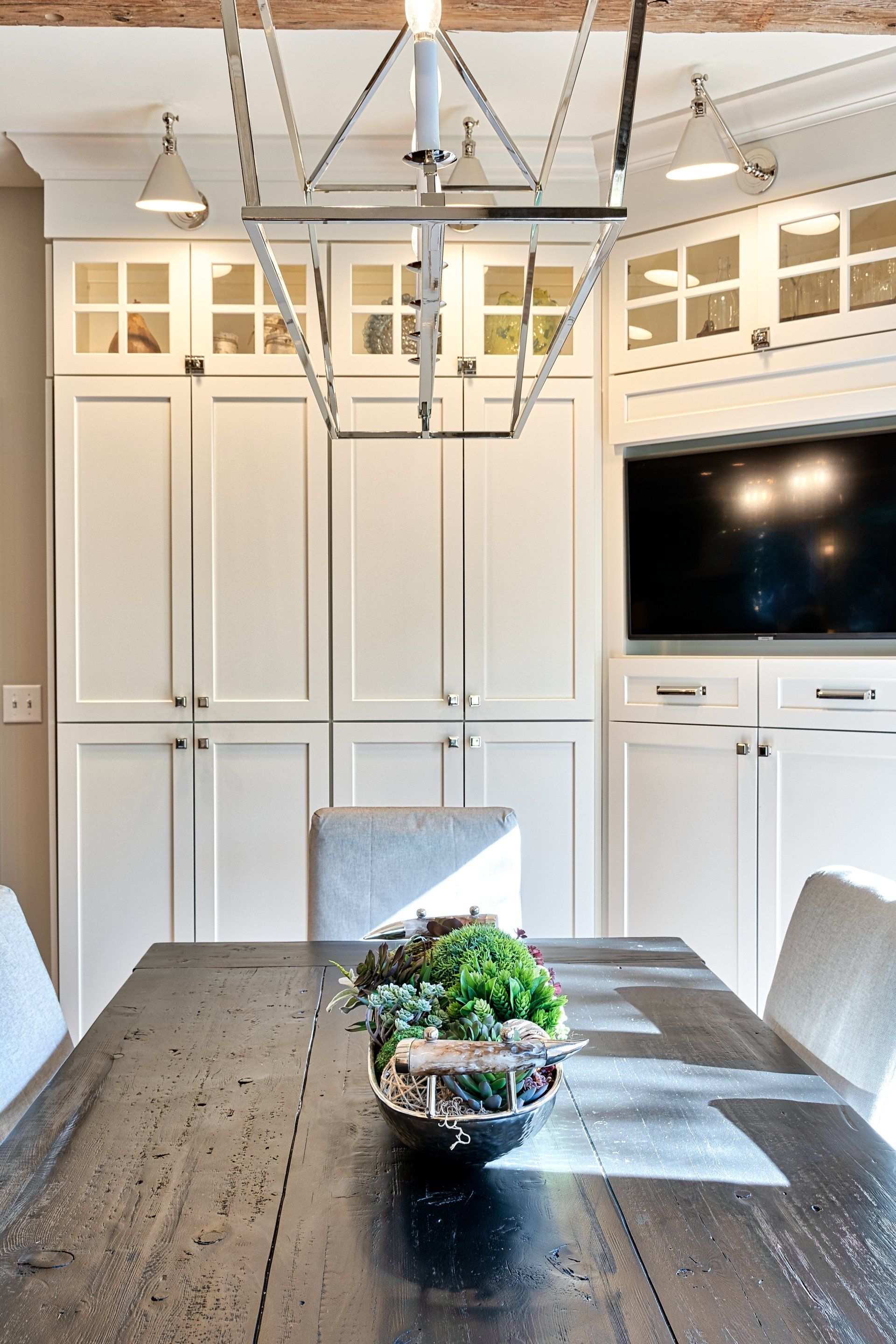 A dining room with a black table and white cabinets