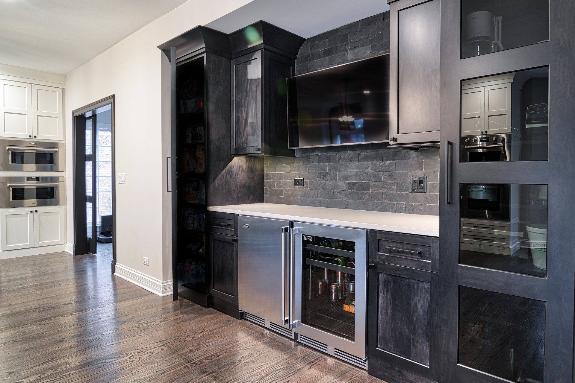 A kitchen with black cabinets and stainless steel appliances