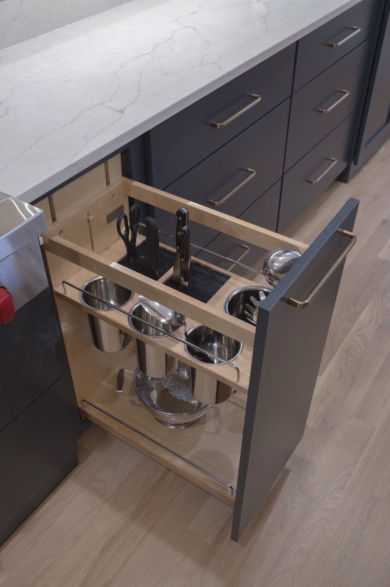 A kitchen drawer with pots and pans in it
