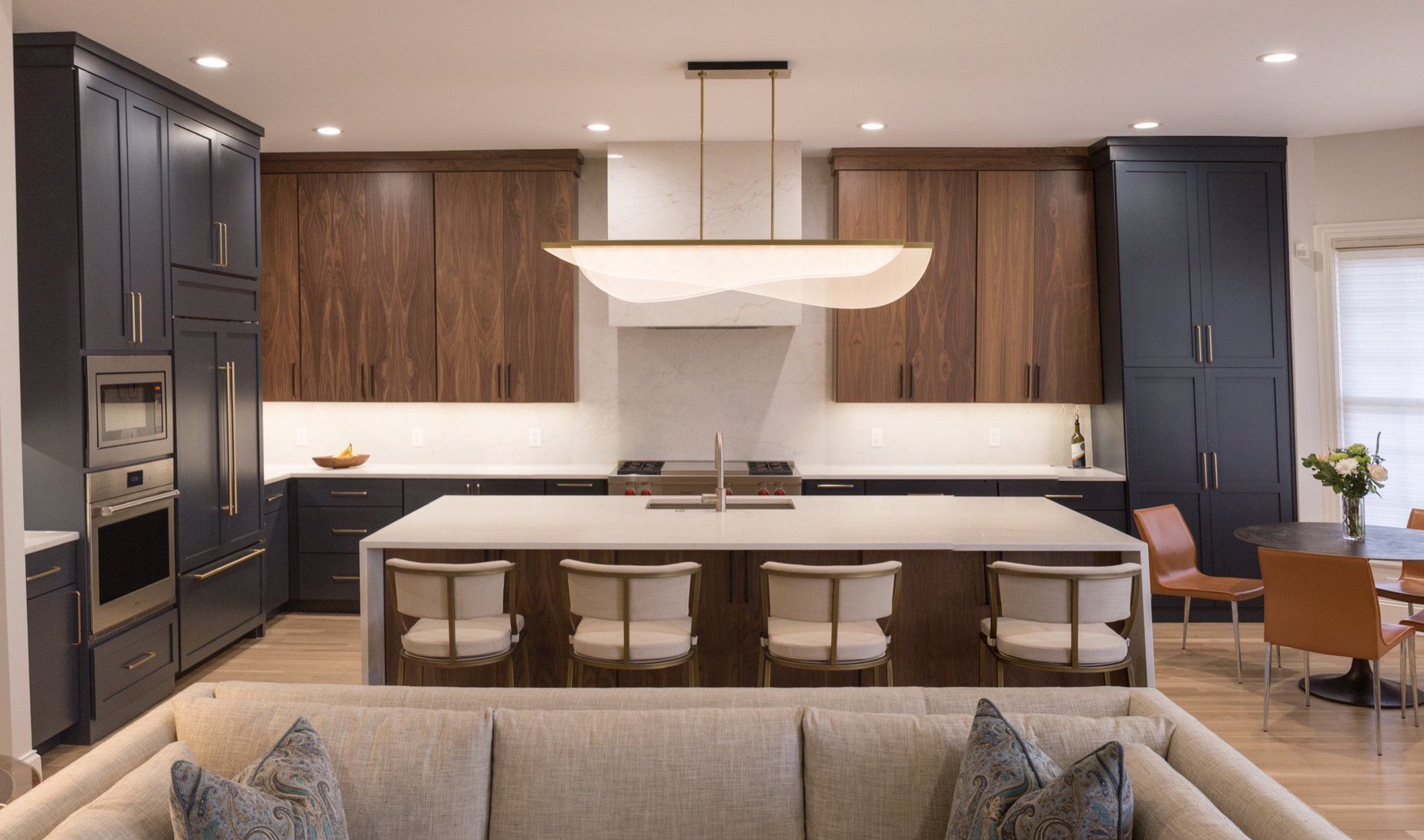 A living room filled with furniture and a kitchen with a large island.