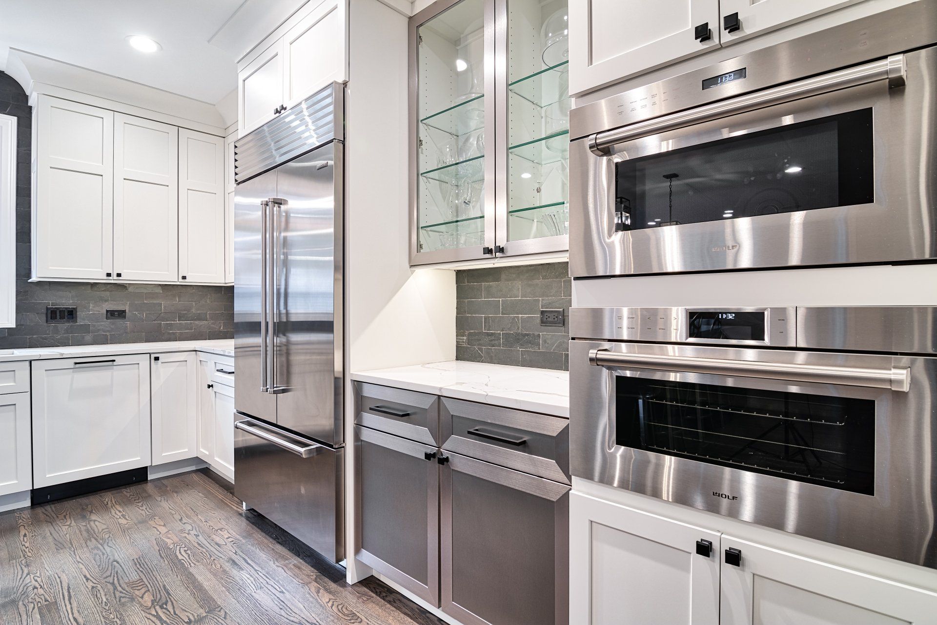 A kitchen with stainless steel appliances and white cabinets.