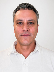 Smiling man in a white shirt against a plain white background