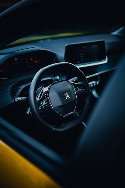 Interior view of a car with a black steering wheel, dashboard, and digital display.