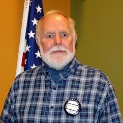 A man with a beard is smiling for the camera.