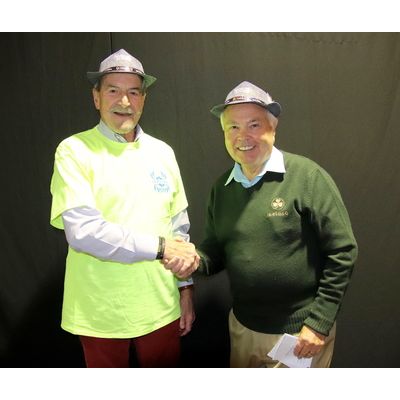 Two men shaking hands in front of a black wall