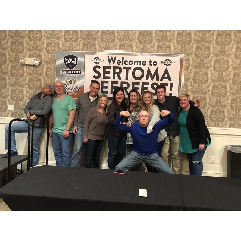 A group of people standing in front of a sign that says welcome to sertoma beerfest