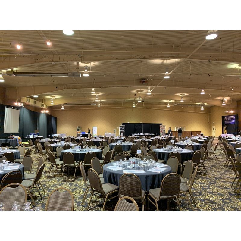 A large room with tables and chairs set up for a conference.