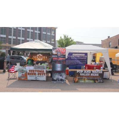 A group of tents are sitting next to each other in a parking lot.