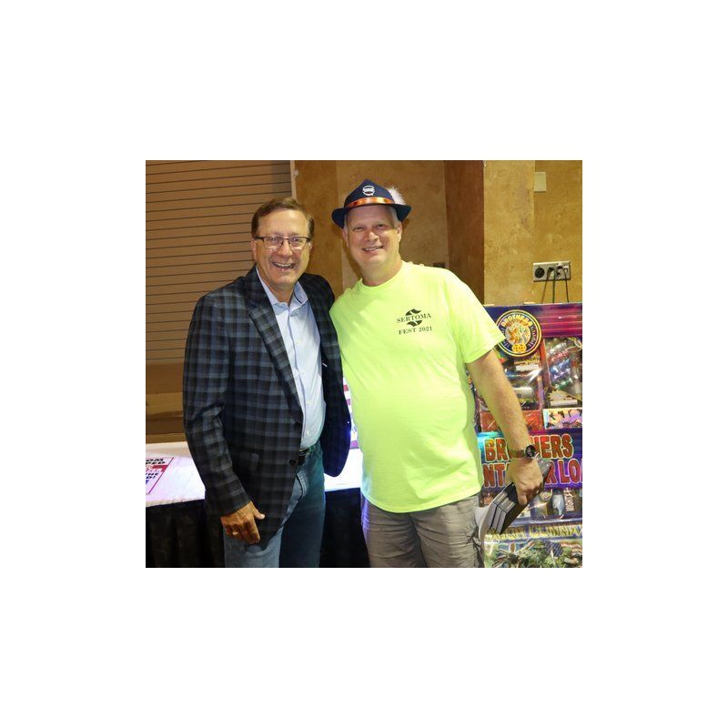 Two men are posing for a picture and one is wearing a neon green shirt