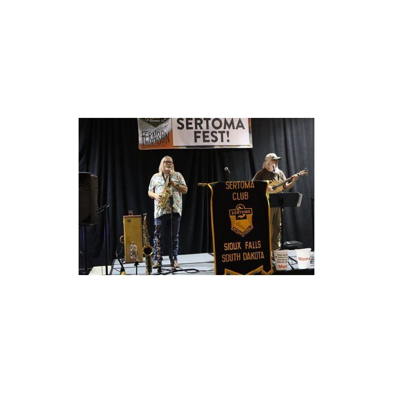 A couple of people standing on a stage playing instruments.