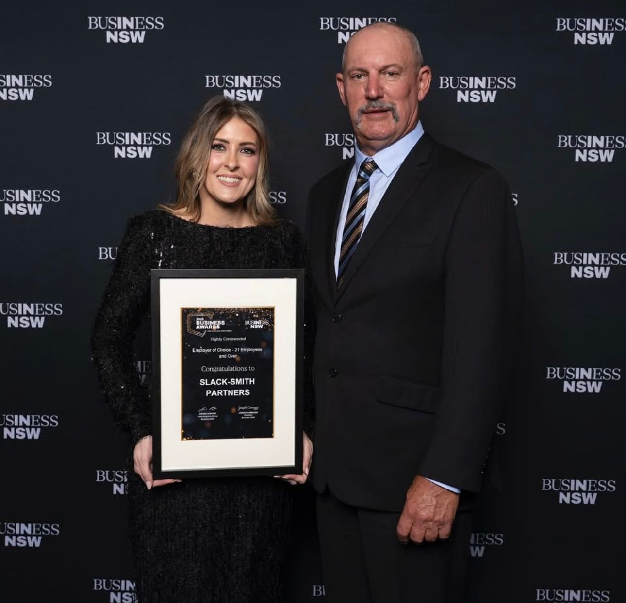 Woman in Black Dress and Man in Suit Stand Next to Each Other — Slack-Smith Partners in Tamworth, NSW
