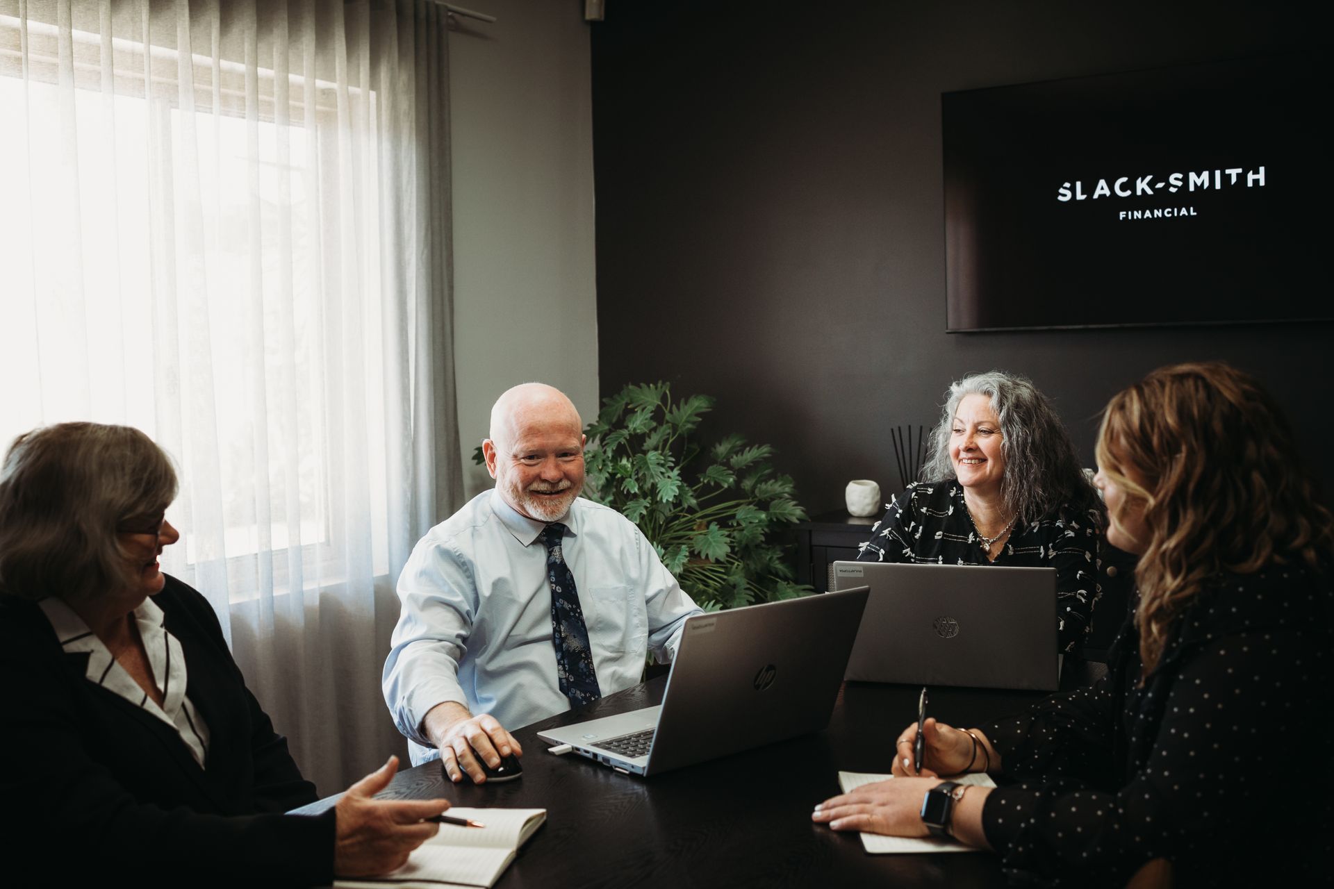 A Group of People Are Sitting at A Desk in Front of A Computer — Slack-Smith Partners in Tamworth, NSW