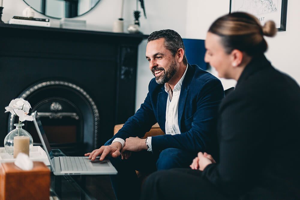 Man and a Woman Are Sitting in Front of a Laptop Computer — Slack-Smith Partners In Moree, NSW