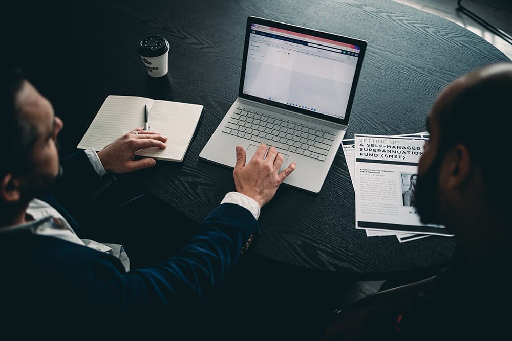 Two Men Looking at a Laptop Computer — Slack-Smith Partners In Moree, NSW