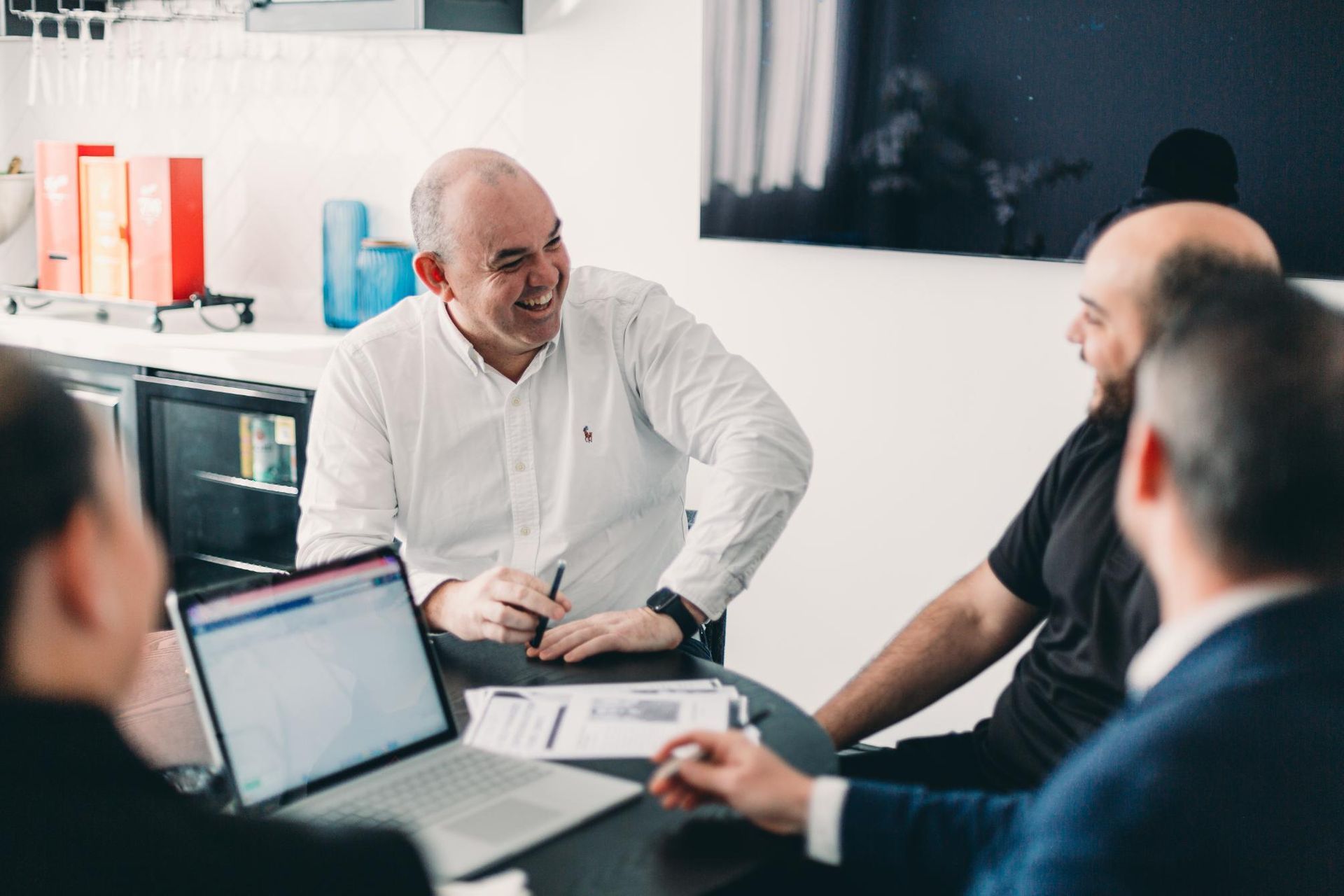 A Group of People Are Sitting Around a Table With Laptops — Slack-Smith Partners  in Punjab, India