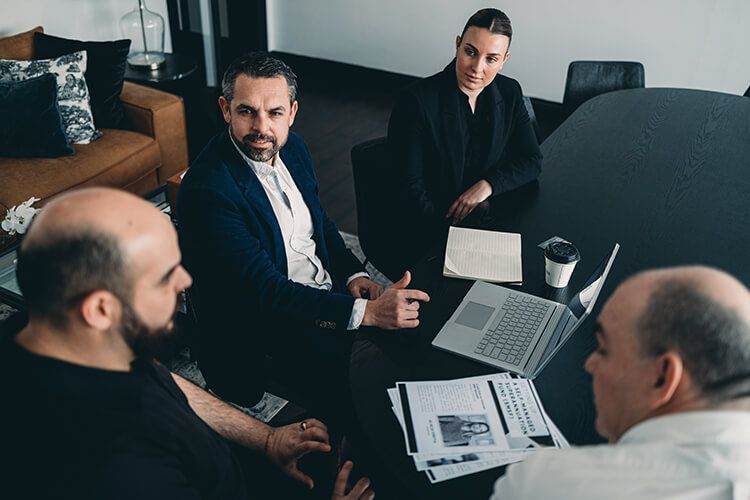 A Group of People Are Sitting Around a Table Having a Meeting — Slack-Smith Partners in Tamworth, NSW