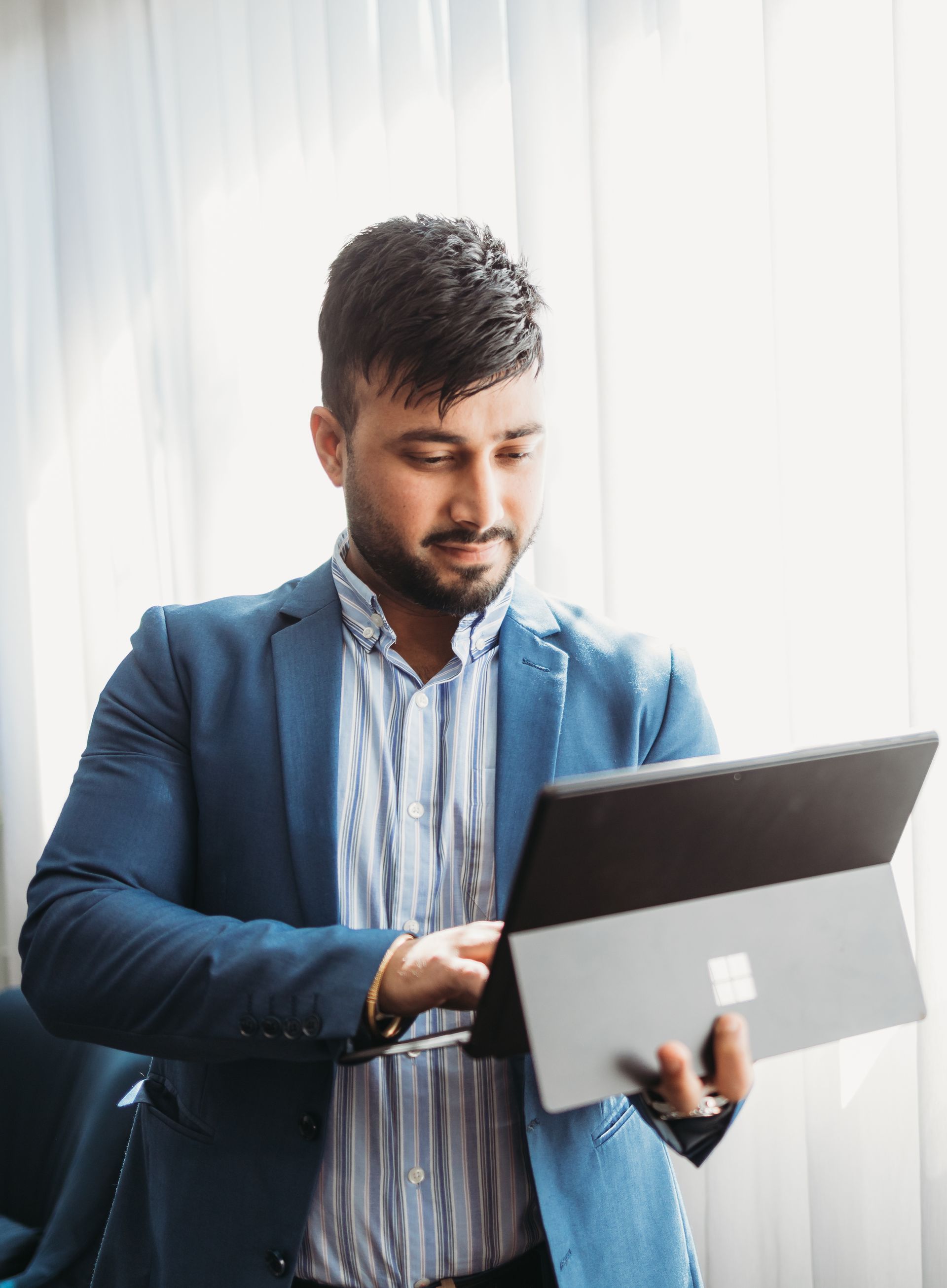 A Man In A Suit Is Using A Tablet Computer — Slack-Smith Partners in Tamworth, NSW