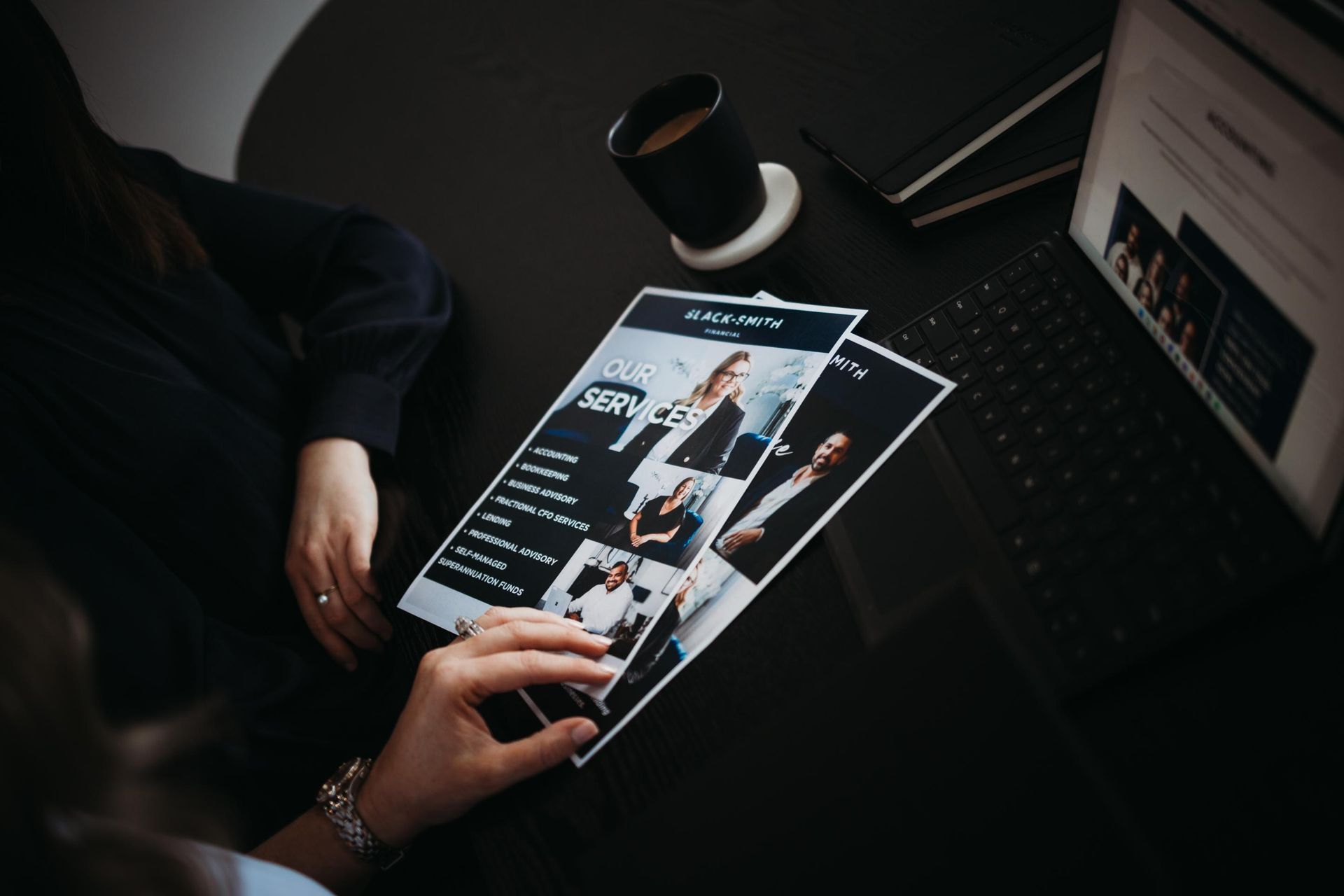A Person Is Holding a Piece of Paper in Front of A Laptop — Slack-Smith Partners in Tamworth, NSW