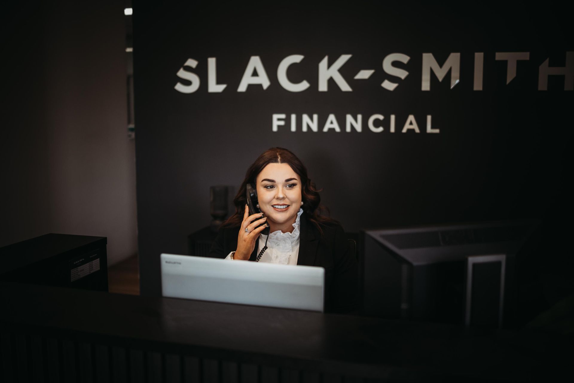 A Woman on Phone Is Sitting at A Front Desk — Slack-Smith Partners in Tamworth, NSW