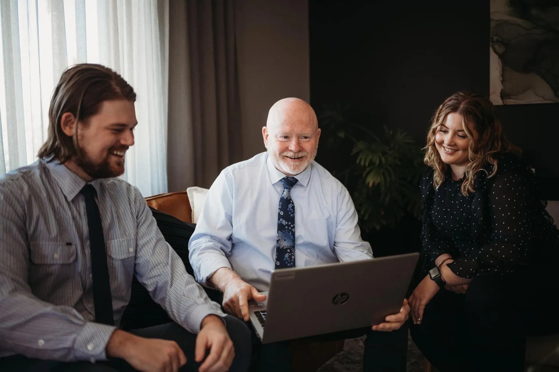 A Group of People Are Sitting Around a Laptop Computer — Slack-Smith Partners in Tamworth, NSW